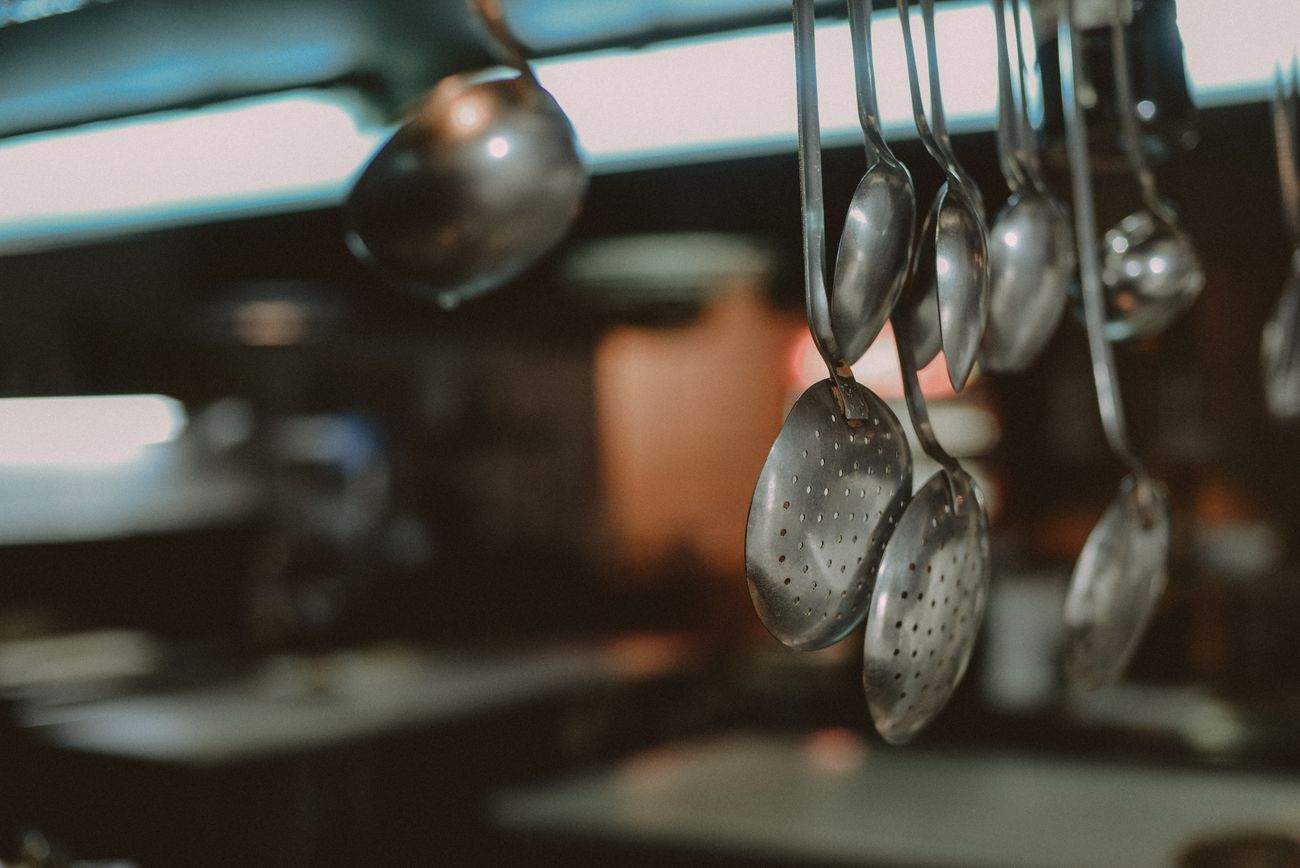 Stainless ladles and spoons hanging in a kitchen