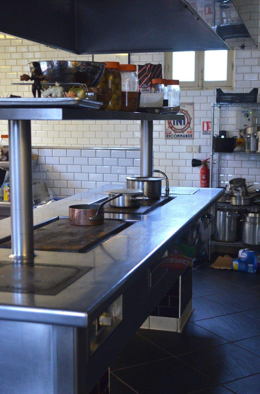 An empty commercial kitchen with stainless steel counters